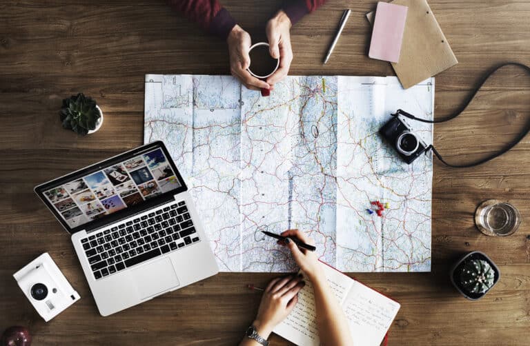 Travel planning with a map and laptop on a desk